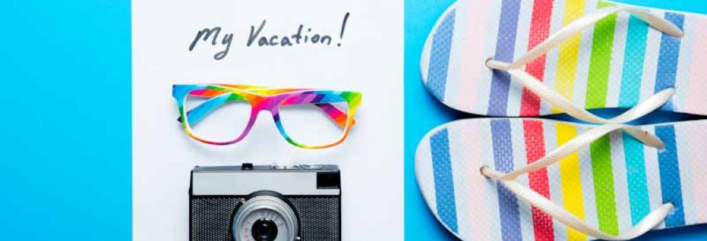 photo of sheet of paper My Vacation, colorful sandals, glasses and retro camera on the wonderful blue studio background