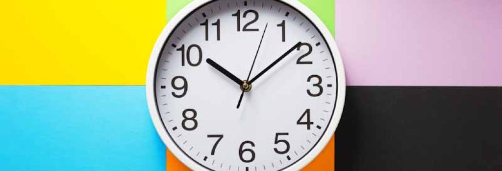 wall clock at abstract colorful paper background texture