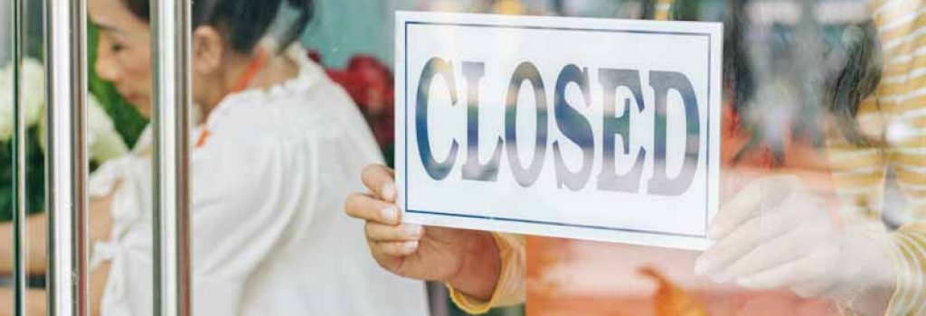 Florist hanging sign on store door and closing shop due to coronavirus pandemic restrictions